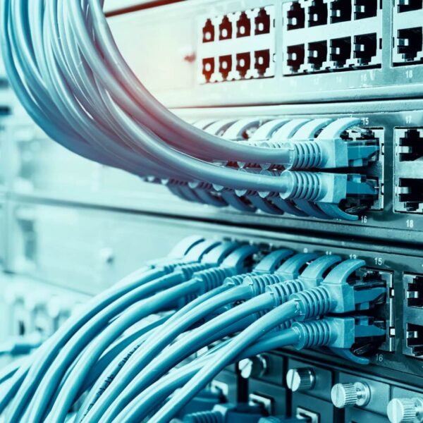 Close-up view of network switches with numerous Ethernet cables plugged into the ports, representing data and internet connectivity in a server room or data center.